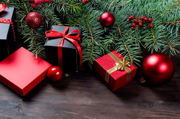 빨간 리본과 전나무 가지가 있는 검정과 빨강 크리스마스 선물 상자