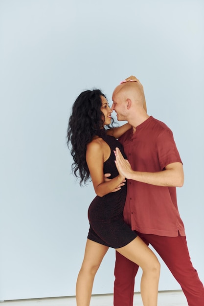 In black and red clothes Cheerful couple is together indoors