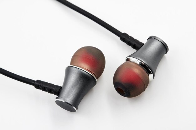 Black red earphones lie on white background