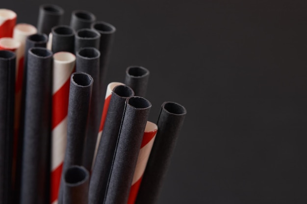 Photo black and red paper straws on black background halloween celebration party