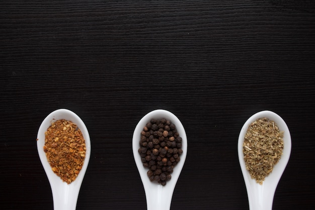 Black and red pepper, set of spices in spoons.