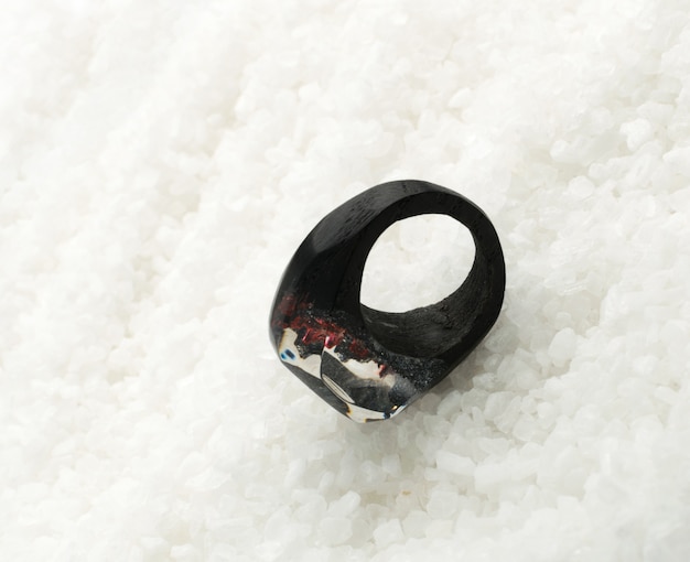 Black and Red Ring Made of Wood and Resin. Handmade Bijouterie on White Crystal Background