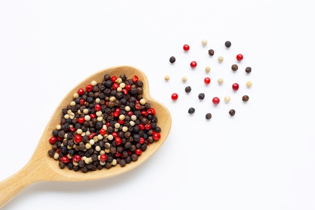 Black, red and white peppercorns with wooden spoon