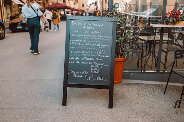 通りにある黒いレストランのメニュー黒板、店の前に料理のリストが記載されたメニュー黒板
