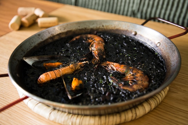 Black rice paella with seafood and fish. Traditional Spanish recipe.