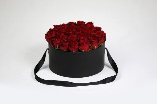 내부에 빨간 장미가 있는 검은색 둥근 선물 꽃 상자