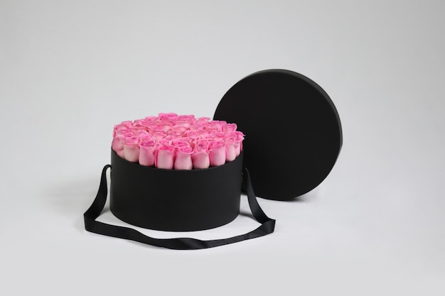 Black round gift flower packaging box with pink roses inside and opened lid