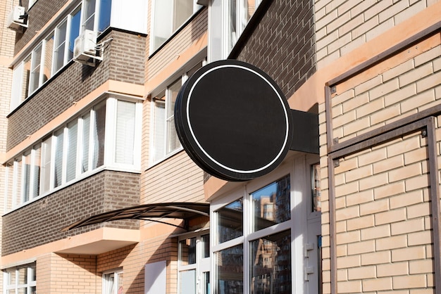 Фото Черный круглый логотип на фасаде здания из кирпичной стены для дизайна макета