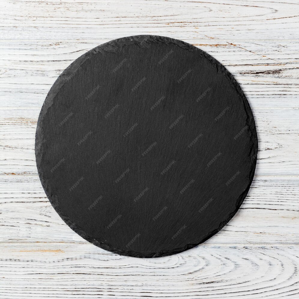 Premium Photo | Black round plate on wooden background top view copy space