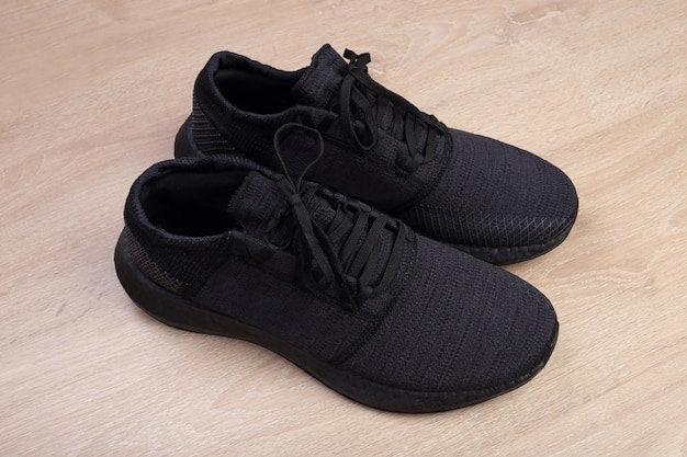 Black running shoes on wooden