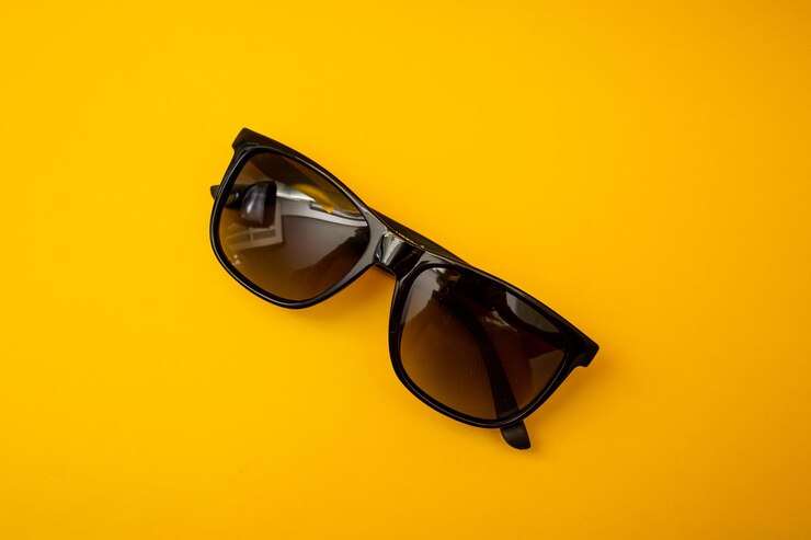 Black s sunglasses on orange background