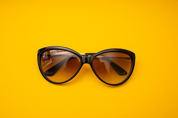 Black s sunglasses on orange background