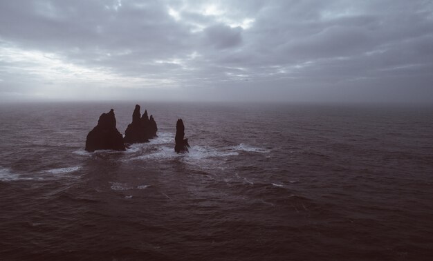 Black sand beach, and basaltic rocks in the ocean in Iceland