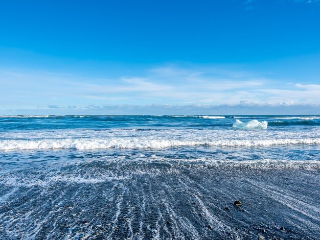 Black sand diamond beach with wave and snow mountains in Iceland