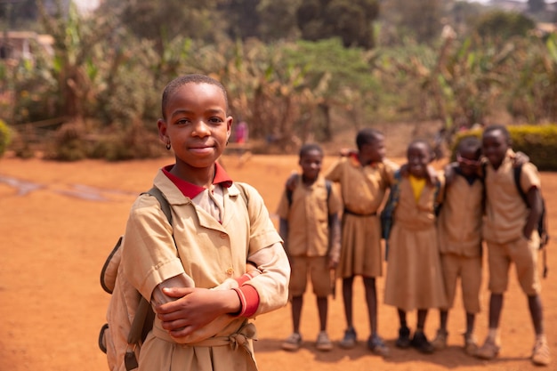 Black schoolgirl in the courtyard standing in the foreground compared to her classmates