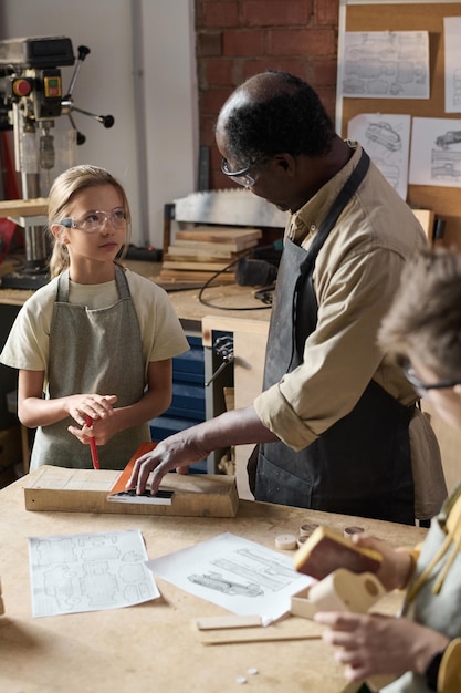 Photo black senior man teaching carpentry class for children