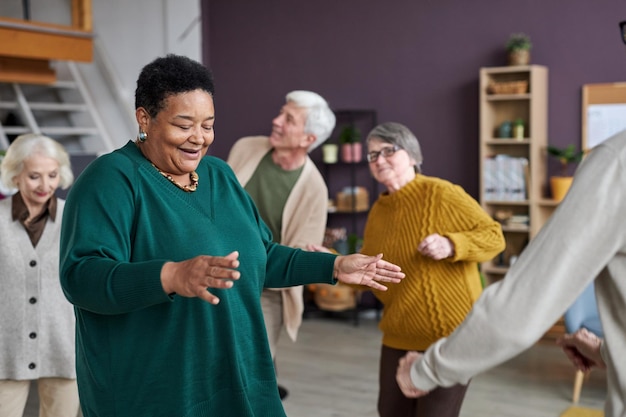 Black senior woman dancing in retirement home and smiling happily