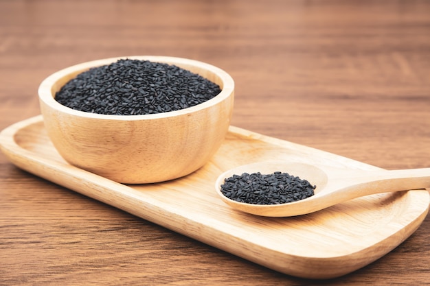 Black sesame seeds in a wooden spoon For healthy food and diet concepts