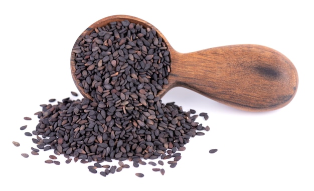 Black sesame seeds in wooden spoon isolated on white background Organic spice