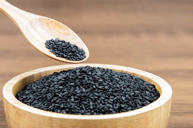 Black sesame seeds in a wooden spoon