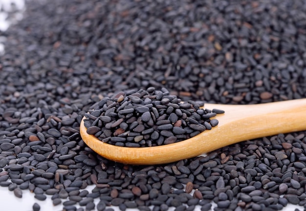 Black sesame seeds in a wooden spoon