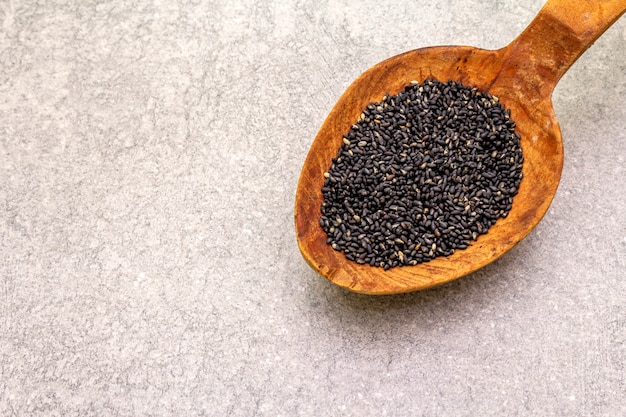 Black sesame seeds in wooden spoon