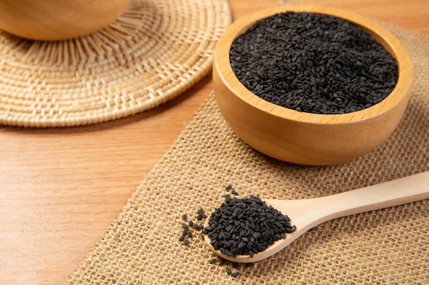 black sesame in wooden spoon and bowlclose up and choose a focus point