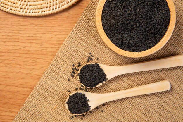 black sesame in wooden spoon and bowlclose up and choose a focus point