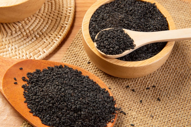 black sesame in wooden spoon and bowlclose up and choose a focus point