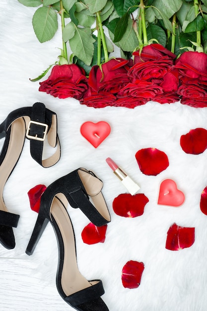 Black shoes and red roses on a white fur