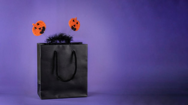 Фото Черная сумка для покупок на темно-фиолетовом фоне. концепция продаж на хэллоуин