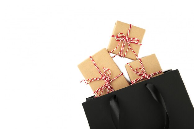 Black shopping bag with gifts isolated on a white .