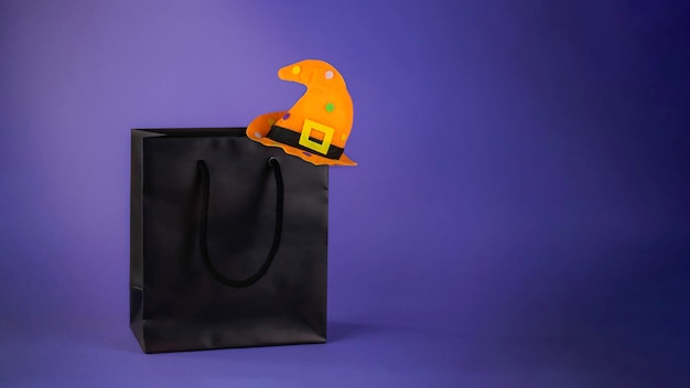 Photo black shopping bag with witch hat. halloween sales concept