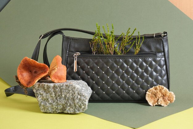 Photo black shoulder bag made of eco leather made from mushroom mycelium, green background, vegan mushroom leather concept, say no to killing animals for fashion