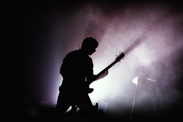 black silhouette of guitarist at rock concert