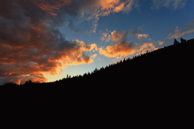 テキストのための山の場所の美しい夕日を背景に山の黒いシルエット