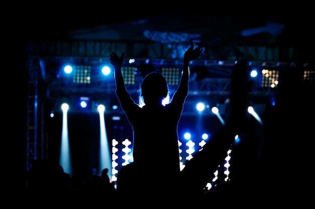 Black silhouette of young girl on rock concert