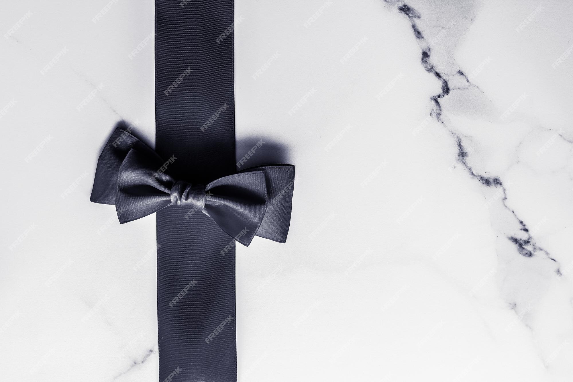 Premium Photo  Black silk ribbon and bow on marble background flatlay