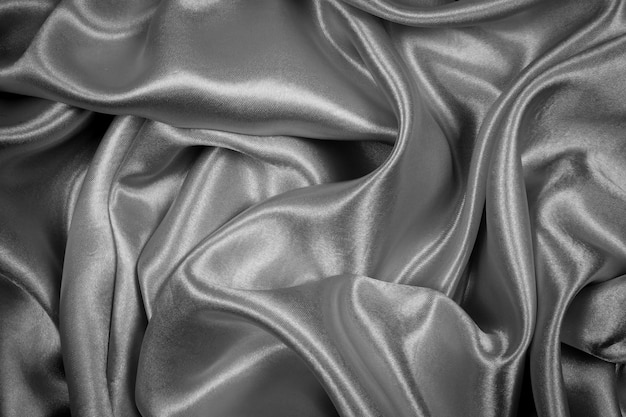 Black silk texture luxurious satin for abstract background. Dark tone of fabric