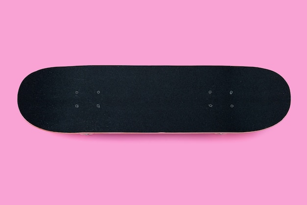 Black skateboard on pink background.