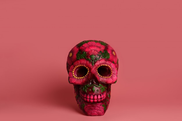 Black skull is decorated with magenta and red flowers