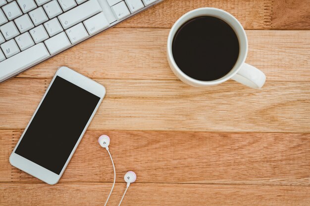 Black smartphone with cup of coffee