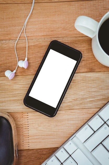 Black smartphone with cup of coffee