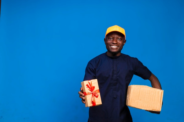 Черный улыбающийся африканский доставщик с коробками подарков