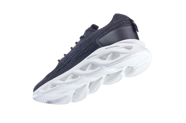 Black sneaker made of fabric with a white sole on a white shoe