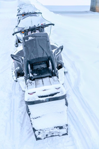 冬の凍った湖の黒いスノーモービルRovaniemi、ラップランド、フィンランド