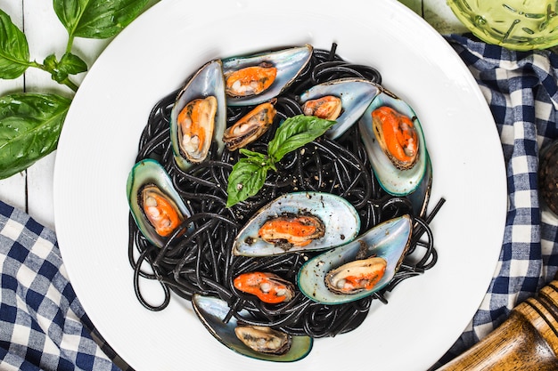Black spaghetti. Black seafood pasta with mussels over black background. 