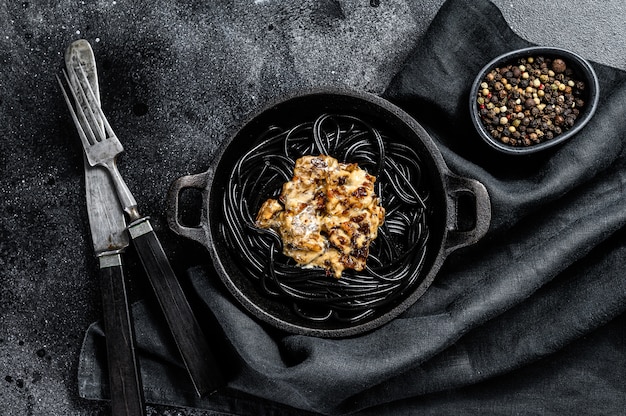 Black spaghetti pasta with squid ink in a pan