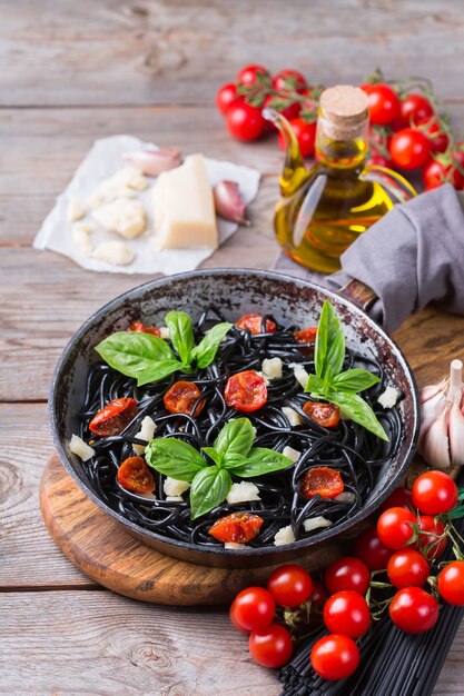 Black spaghetti pasta with tomatoes cheese and basil