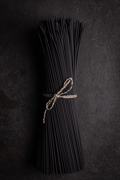 Фото Черные спагетти с чернилами каракатицы на темном фоне